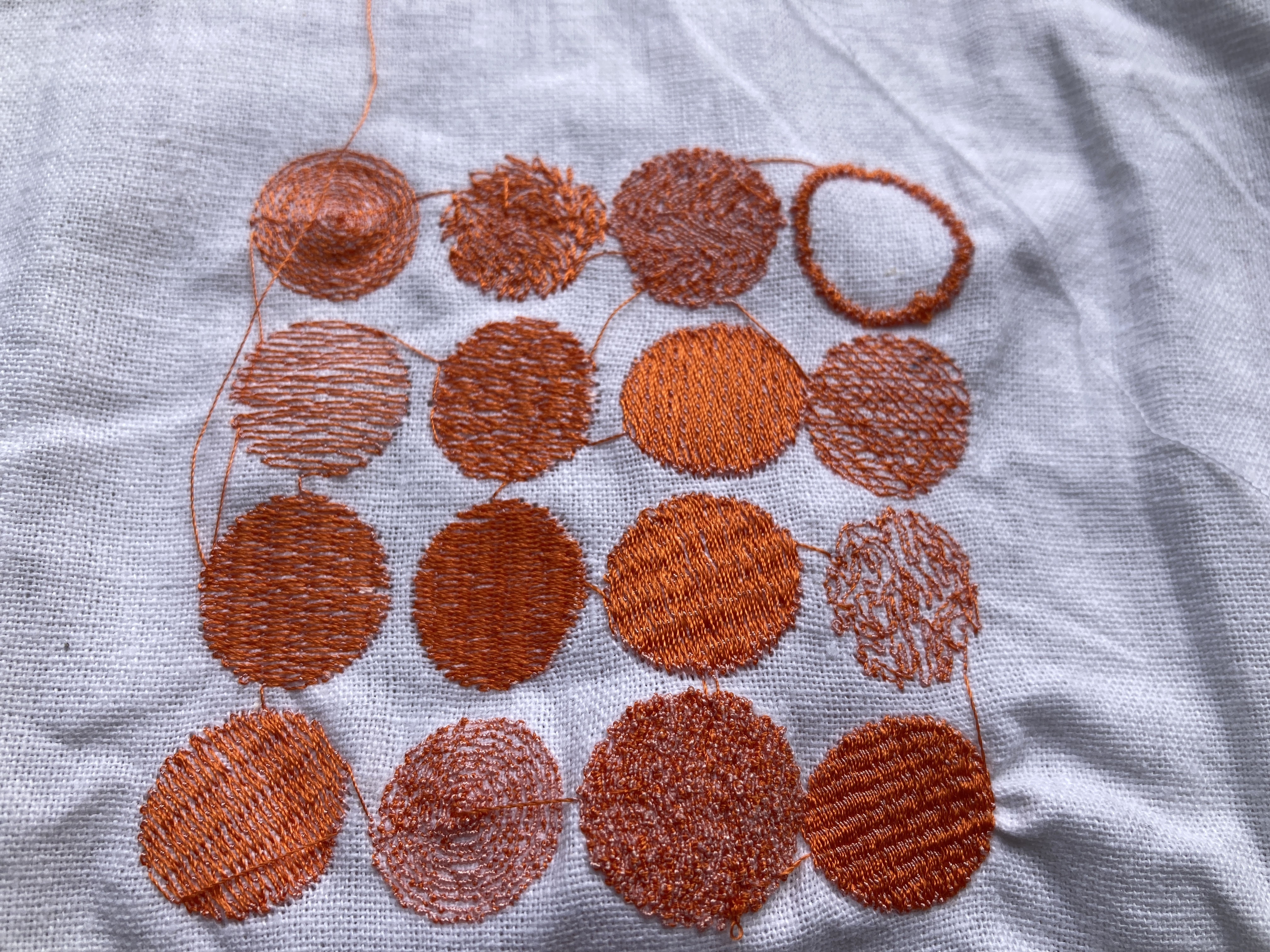 12 embroidered circles in a grid with different patterns 